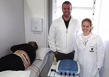 Fisioterapeutas Renan de Bom e Aline Pereira com a paciente Neuza
